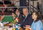 Innenminister Joachim Herrmann am Tisch neben anderen Gästen, im Hintergrund Bühne mit Musikern 