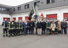 Gruppenfoto der Freiwilligen Feuerwehr Erlangen mit Innenminister Herrmann und Drehleiterfahrzeug