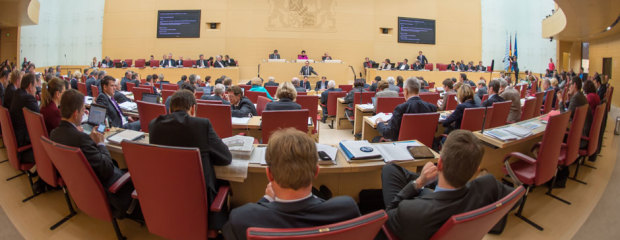 Abgeordnete sitzen im Bayerischen Landtag und blicken in Richtung Präsidium.