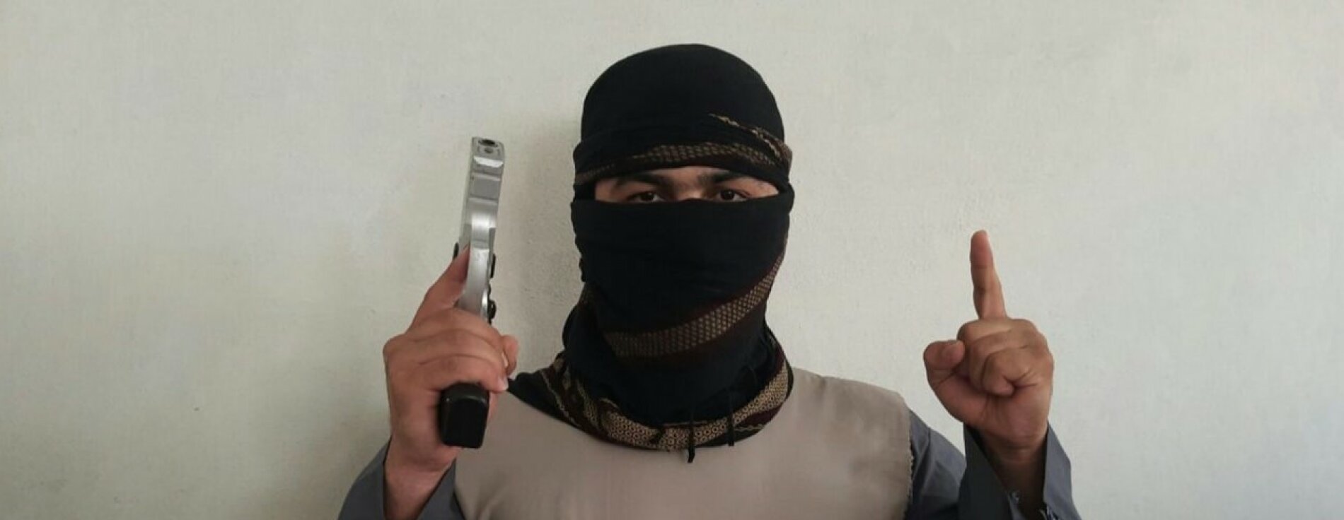 Das Bild zeigt einen Jihadisten - vermummt mit Waffe und Tauhid-Finger